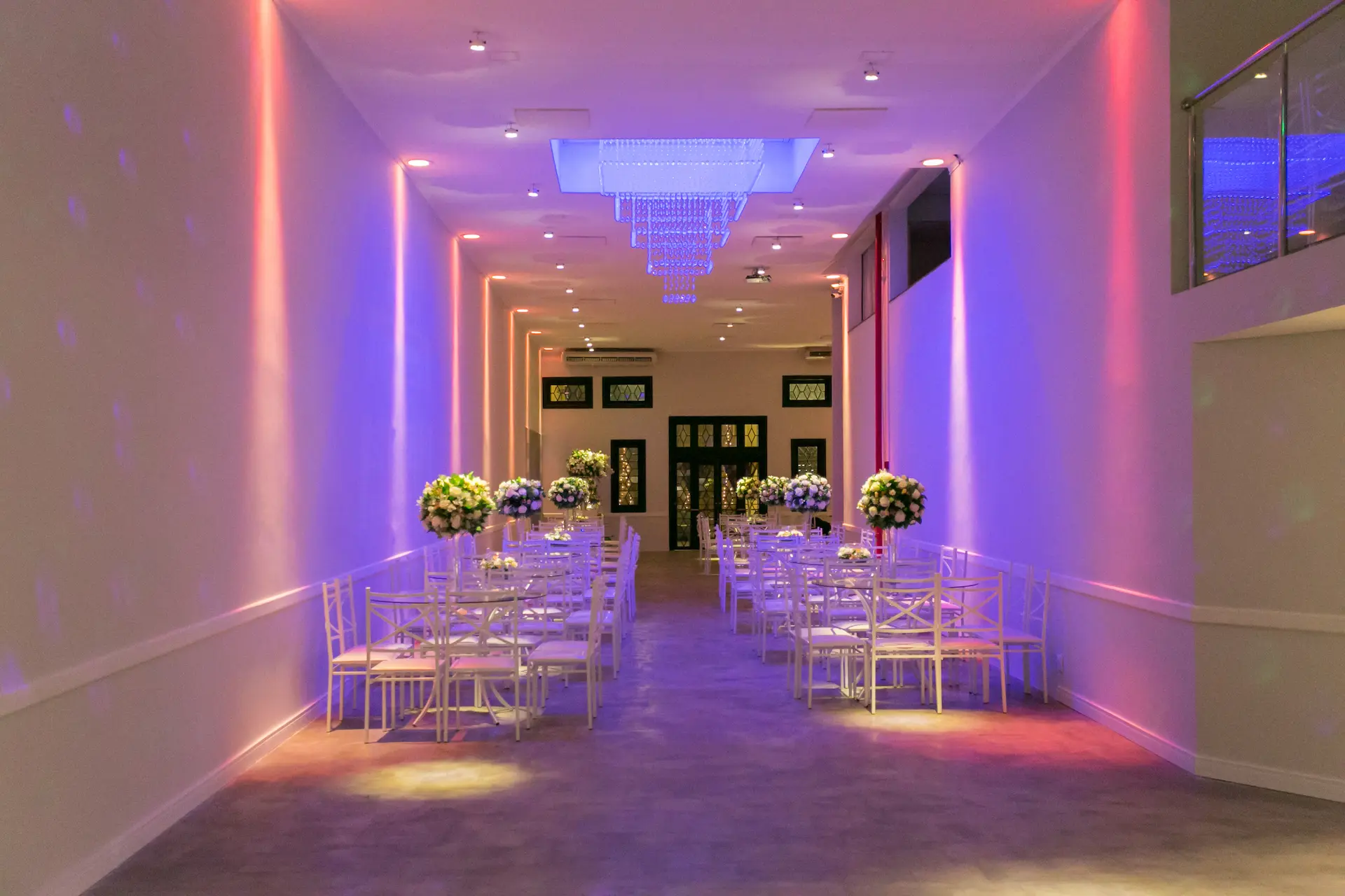 Salão do Espaço Pallazium preparado para um evento, com mesas, flores e iluminação